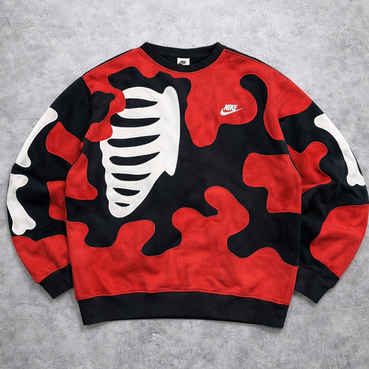 Red, black, and white camouflage-patterned sweatshirt with a Nike logo on a gray background